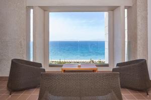 a room with a view of the ocean from a window at Sheraton Rhodes Resort in Ixia