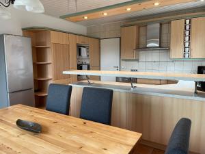 a kitchen with a wooden table and blue chairs at A & B Apartment und -Zimmervermietung eGbr in Tornesch