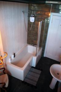 a bathroom with a bath tub and a sink at Grand top floor apartment in the Royal Bank House in Maybole
