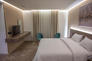 a hotel room with a bed and a television at فندق بلاتينيوم الاولي الفندقية in Al Madinah