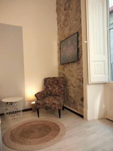 salon z krzesłem i dywanem w obiekcie Al Campanile w mieście Piazza Armerina