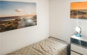 a bedroom with a bed and a painting on the wall at Zeekalfje in Bergen aan Zee