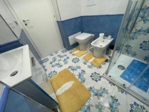 ein blau-weißes Bad mit einem WC und einem Waschbecken in der Unterkunft La Stanza di Penelope in Neapel