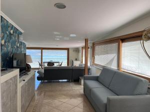 a living room with a couch and a piano at Kalaskiso' in Giardini Naxos