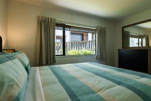 a bedroom with a bed and a large window at Magic mountain Vista in Queenstown