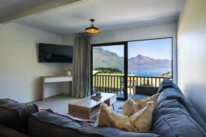 a living room with a couch and a large window at Magic mountain Vista in Queenstown