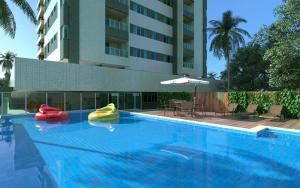 a large swimming pool with two rubber boats in it at Apartamento Completo Jatiúca in Maceió