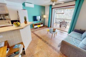 uma sala de estar com um sofá e uma mesa em Seadream Paradise appartement vue piscine à 150m de la plage em Saint Martin