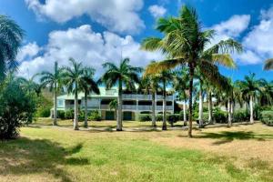 a building with palm trees in front of it at Seadream Paradise appartement vue piscine à 150m de la plage in Saint Martin