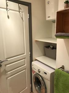 uma cozinha com uma máquina de lavar roupa e uma porta branca em Seadream Paradise appartement vue piscine à 150m de la plage em Saint Martin