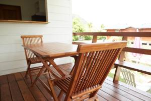 een houten tafel en 2 stoelen op een veranda bij Le dauphin de te ava iti in Matiti