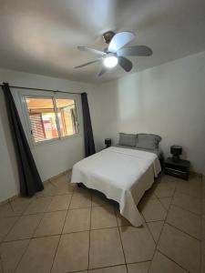 a bedroom with a bed and a ceiling fan at La villa exotik in Saint-Louis +24 photos