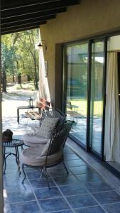 un porche con sillas y una mesa en el patio en Ranchito- casita de huespedes, en Alta Gracia