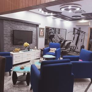 a living room with blue chairs and a tv at White Lotus Corporate Business Boutique in Karachi