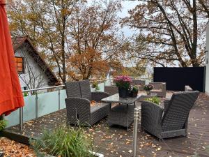 a patio with wicker chairs and a table on a deck at Fewo Elegance in Binz