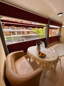 a living room with a table and a chair at Olivia SunSet Uno in Puerto de Santiago