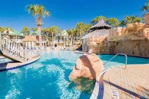 a swimming pool in a resort with palm trees at Boogie Man 36C By Pkrm in Pensacola