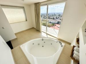 a large white bath tub in a bathroom with a window at Hotel Stadium in León