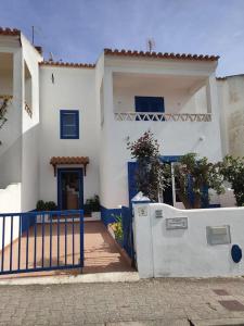 a white house with a blue gate and a fence at Casa Guerreiro in Longueira