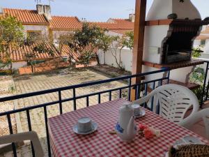 stół z czerwoną i białą tkaniną na balkonie w obiekcie Casa Guerreiro w mieście Longueira