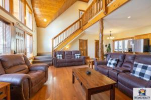 a living room with leather furniture and a wooden ceiling at Forest Heights Lodge - 6BR - Pool Table - Near Silver Dollar City - FREE TICKETS INCLUDED in Branson