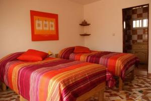 2 Betten nebeneinander in einem Zimmer in der Unterkunft Résidence Keur Fleurie in Toubab Dialao