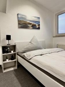 a bedroom with a bed and a painting on the wall at Ferienwohnung Flaming House Bitterfeld in Bitterfeld