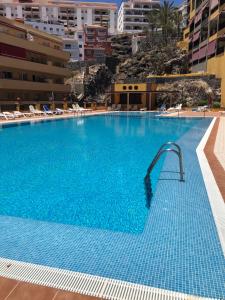 a large blue swimming pool with a water slide at Olivia SunSet Uno in Puerto de Santiago
