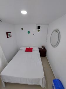 a bedroom with a white bed with a red pillow at Apartamento en cartagena in Cartagena de Indias