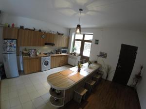 a kitchen with a wooden table and a kitchen with a refrigerator at Glide Hostel in Yerevan