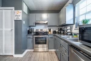 una cucina con elettrodomestici in acciaio inossidabile e armadietti grigi di Amazing and Beautiful Home in Atlanta ad Atlanta
