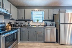 una cucina con armadietti bianchi ed elettrodomestici in acciaio inossidabile di Amazing and Beautiful Home in Atlanta ad Atlanta