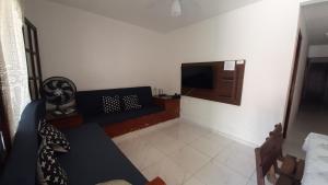 sala de estar con sofá y TV en Apto Peró Cabo Frio 700m da Praia, en Cabo Frío