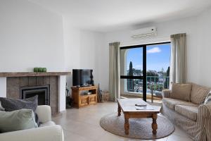 ein Wohnzimmer mit einem Sofa und einem Kamin in der Unterkunft Carvoeiro -Spacious 2 bedroom appartment with pool - Monte Dourado in Carvoeiro