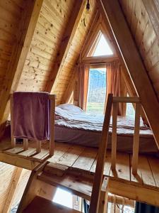 a bedroom in a log cabin with a window at The view in Bijelo Polje