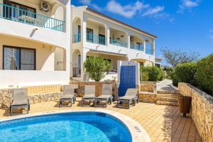 eine Villa mit einem Pool und einem Haus in der Unterkunft Carvoeiro -Spacious 2 bedroom appartment with pool - Monte Dourado in Carvoeiro