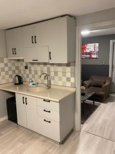 a kitchen with white cabinets and a living room at ATABAY SUiT OTEL in Istanbul