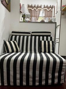 a black and white bed with two pillows on it at Cantinho do Thiê in Paquetá