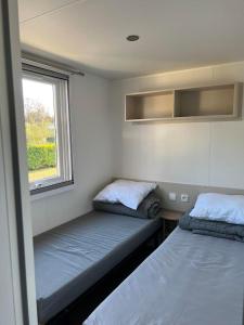 2 Betten in einem kleinen Zimmer mit Fenster in der Unterkunft MH Kerlann 4* Finistère Sud 237 in Pont-Aven