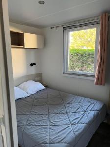 Schlafzimmer mit einem Bett und einem Fenster in der Unterkunft MH Kerlann 4* Finistère Sud 237 in Pont-Aven