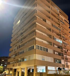 un edificio de apartamentos alto por la noche en PLAYALUZ, en Aguadulce