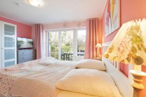 een slaapkamer met roze muren, een bed en een raam bij KON-003-3-Zimmer-Ferienwohnung in Scharbeutz