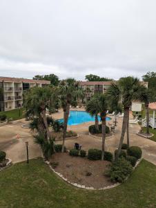 una vista aérea de un complejo con piscina y palmeras en Biloxi Beach Condo-B en Biloxi