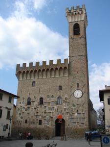 a large brick building with a clock tower at Hotel Dei Vicari in Scarperia