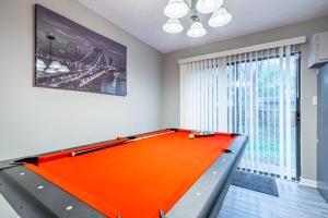 an orange pool table in a room with a window at Vibrant & peaceful home in Atlanta with Pool Table in Atlanta