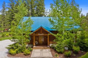 a log cabin with a blue roof at Big Jim Mountain Lodge in Leavenworth