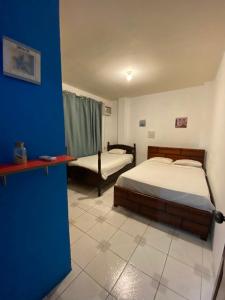 a bedroom with two beds and a blue wall at Playa Aparts & Suites Malecon in Manta