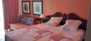 a bedroom with a large bed and a couch at Le MaDja'Kaz - studio en résidence et bord de Mer - Sainte Luce Martinique in Sainte-Luce