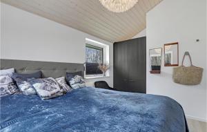 1 dormitorio con 1 cama con edredón azul en 3 Bedroom Nice Home In Aakirkeby en Vester Sømarken