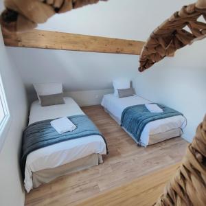 twee bedden in een kamer met houten vloeren bij Domaine Saint Loup - Gîte "Le Petit Loup" - 6 pers- 10min BEAUNE in Saint-Loup-Géanges